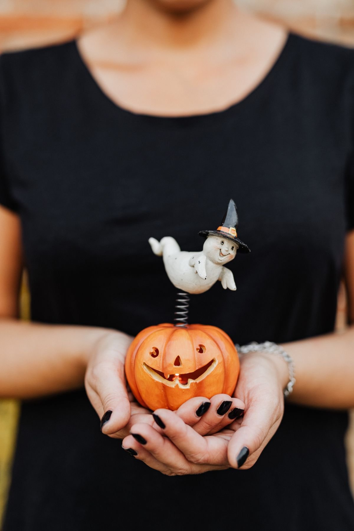White smiling ghost garland draped across a bookshelf as cute halloween home decor