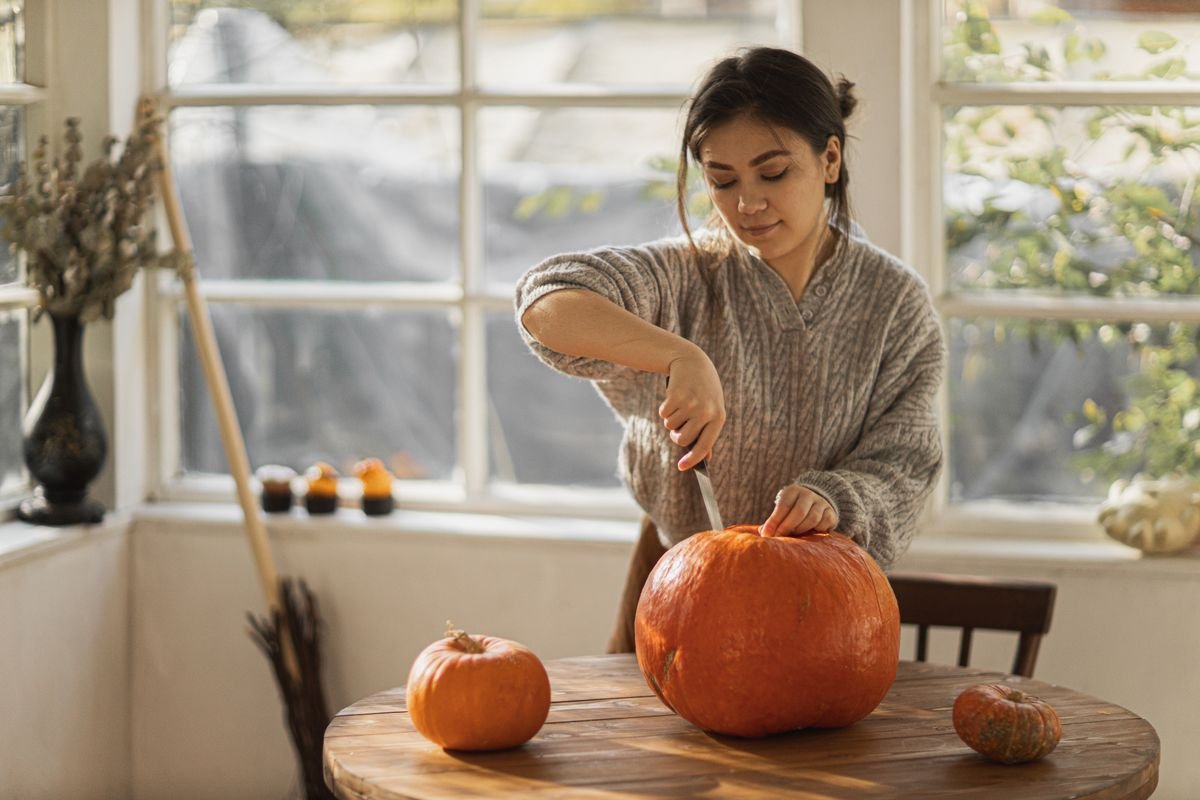 person adding halloween decorations to autumn decorated home