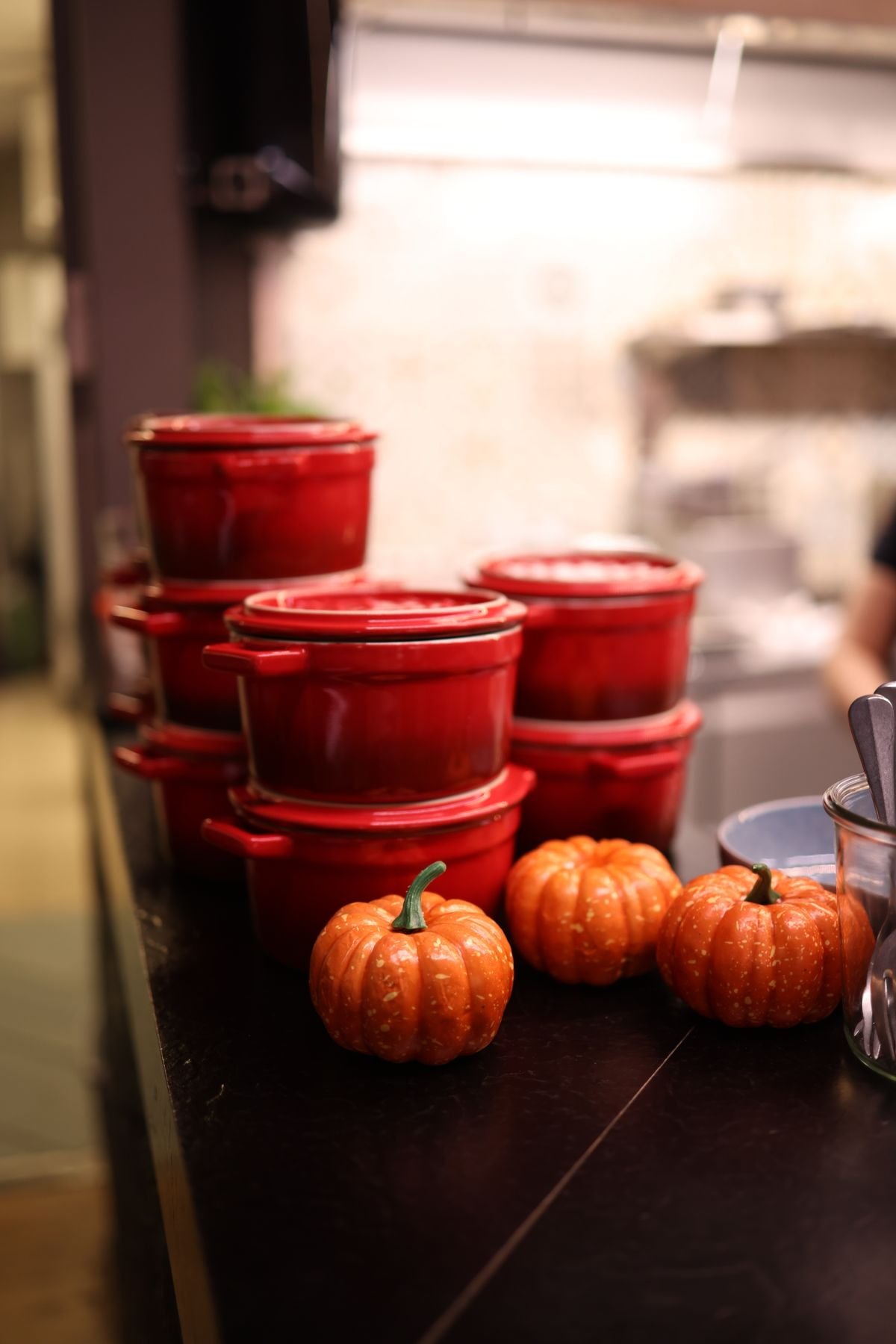Kitchen counter styled with pumpkins, copper pots and fall foliage, cozy autumn kitchen