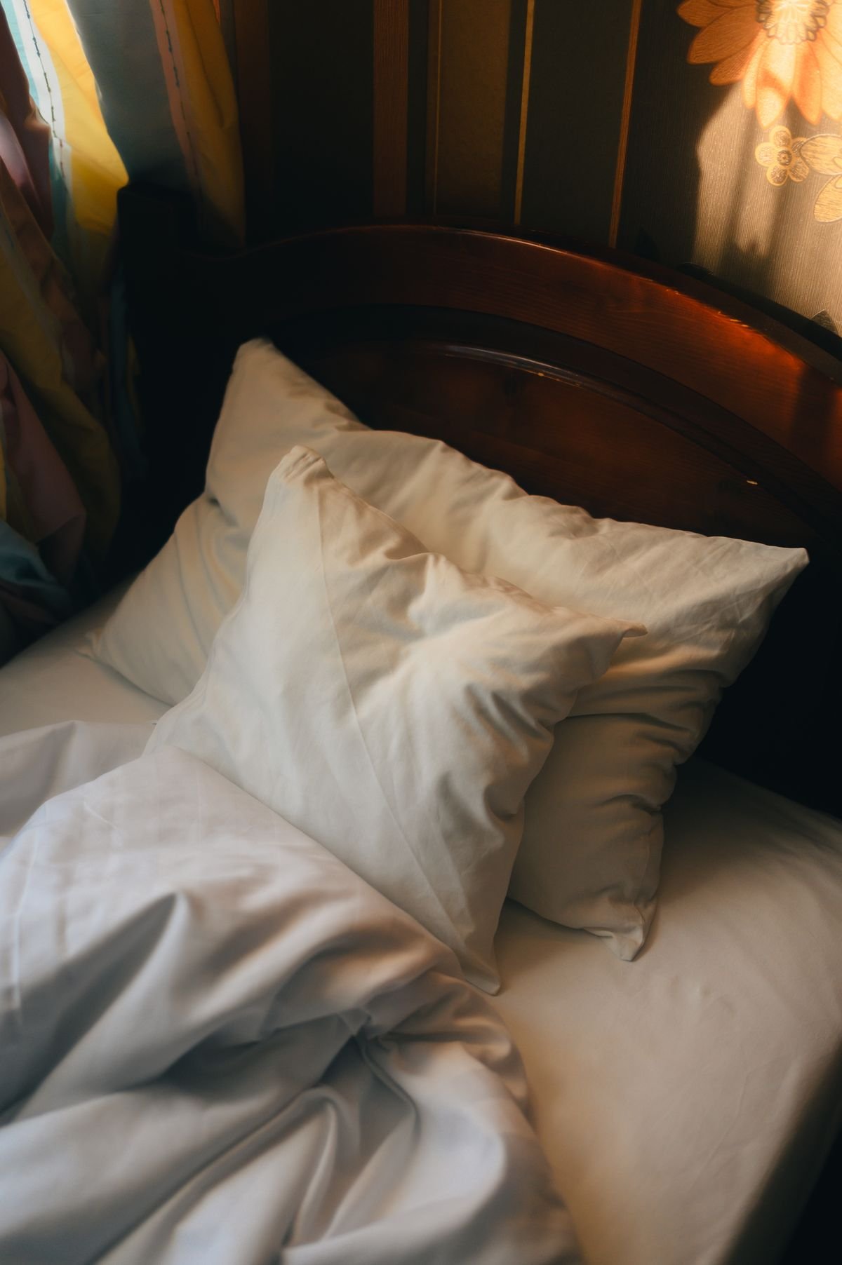 Bed styled with rust and cream pillows for autumn, cozy fall bedroom decor