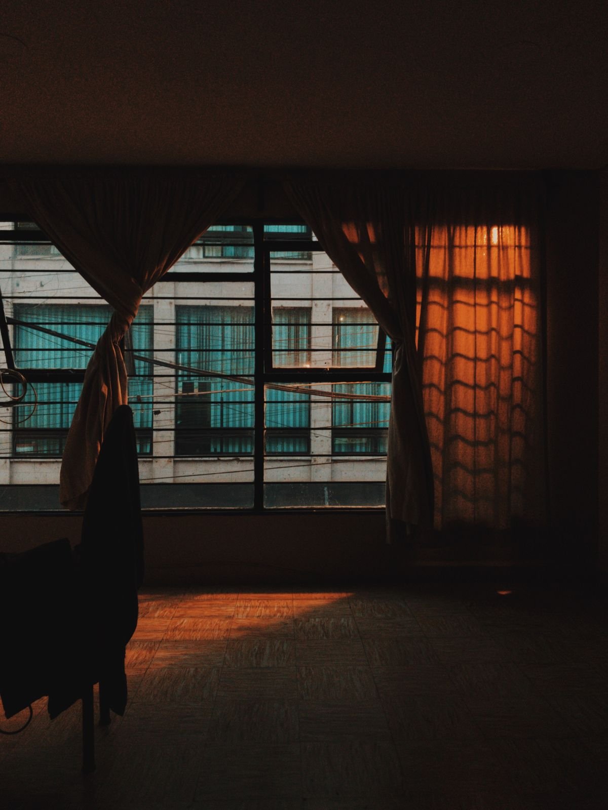 Window glowing warmly at dusk with autumn decor inside, cozy fall home evening