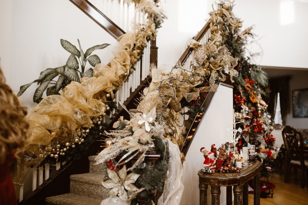 Staircase banister wrapped in autumn garland with lights, fall home decor