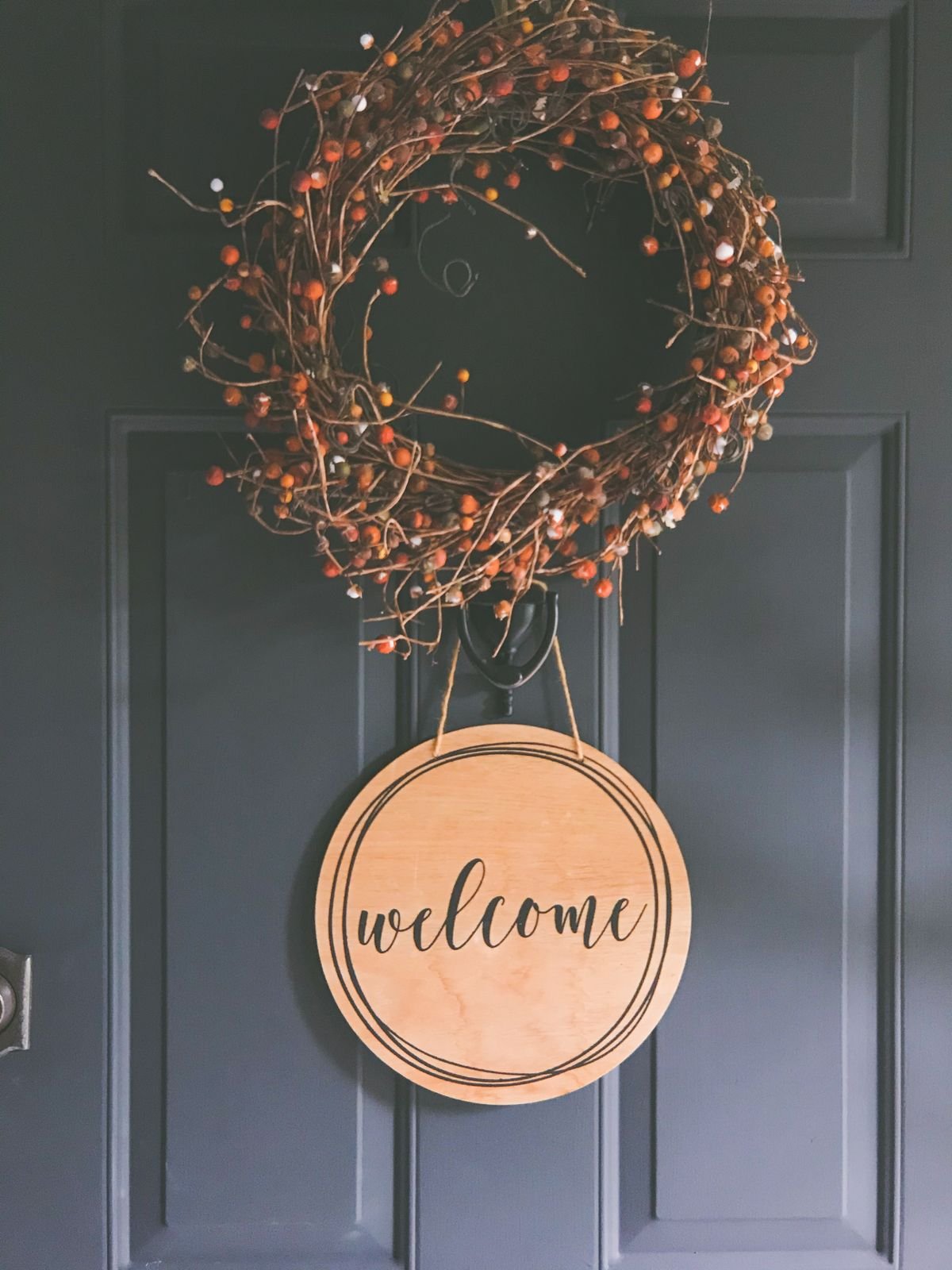 Wooden fall welcome sign leaning on a front porch, autumn porch decor ideas