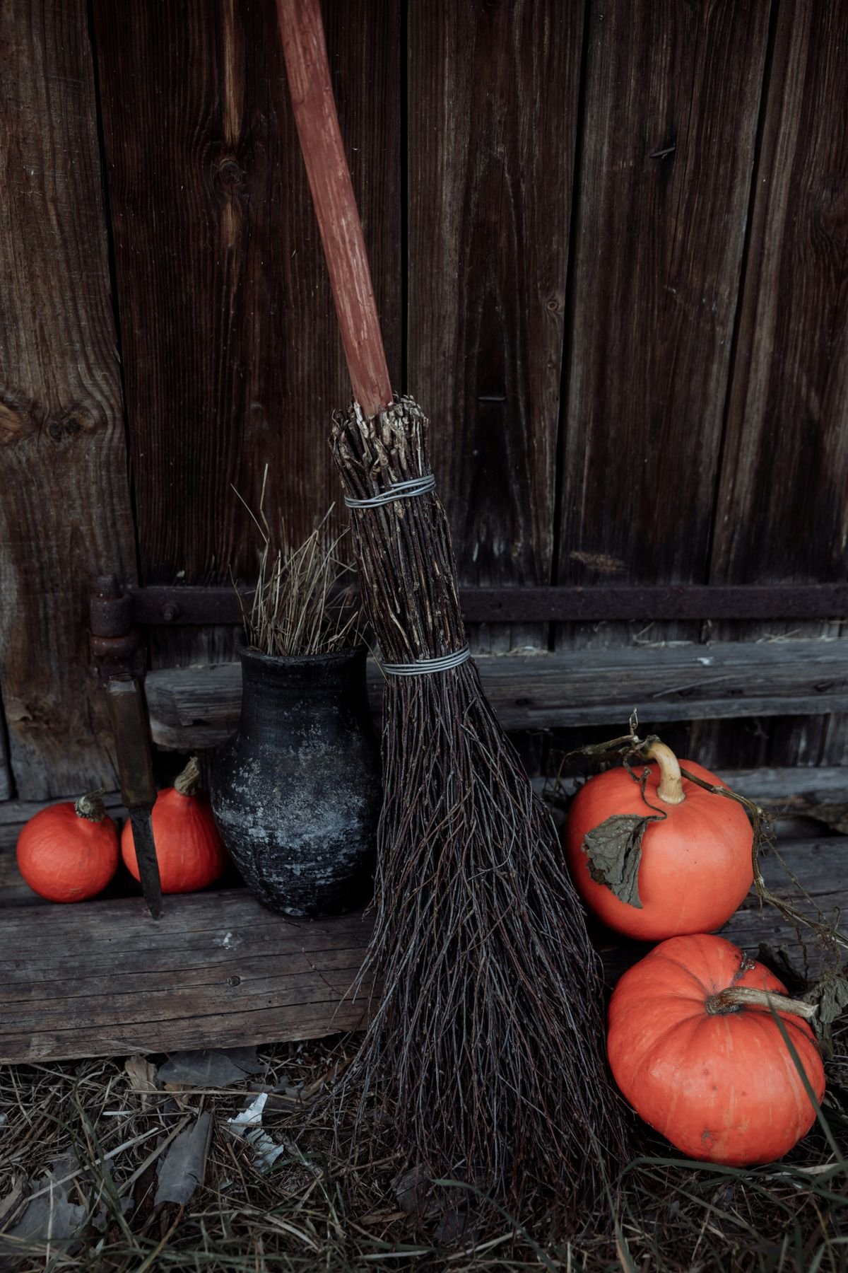 Decorative witch broom leaning by a front door for halloween entry decor