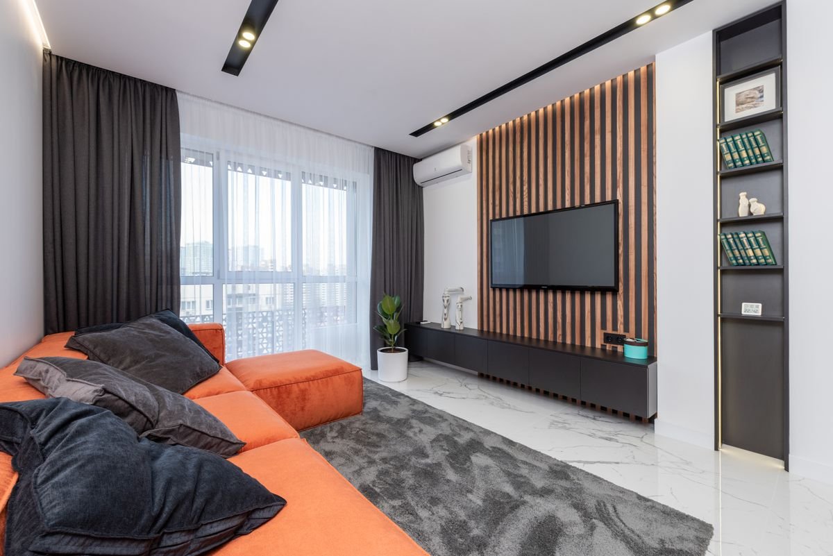 Sofa styled with orange throws and black cushions for halloween living room decor