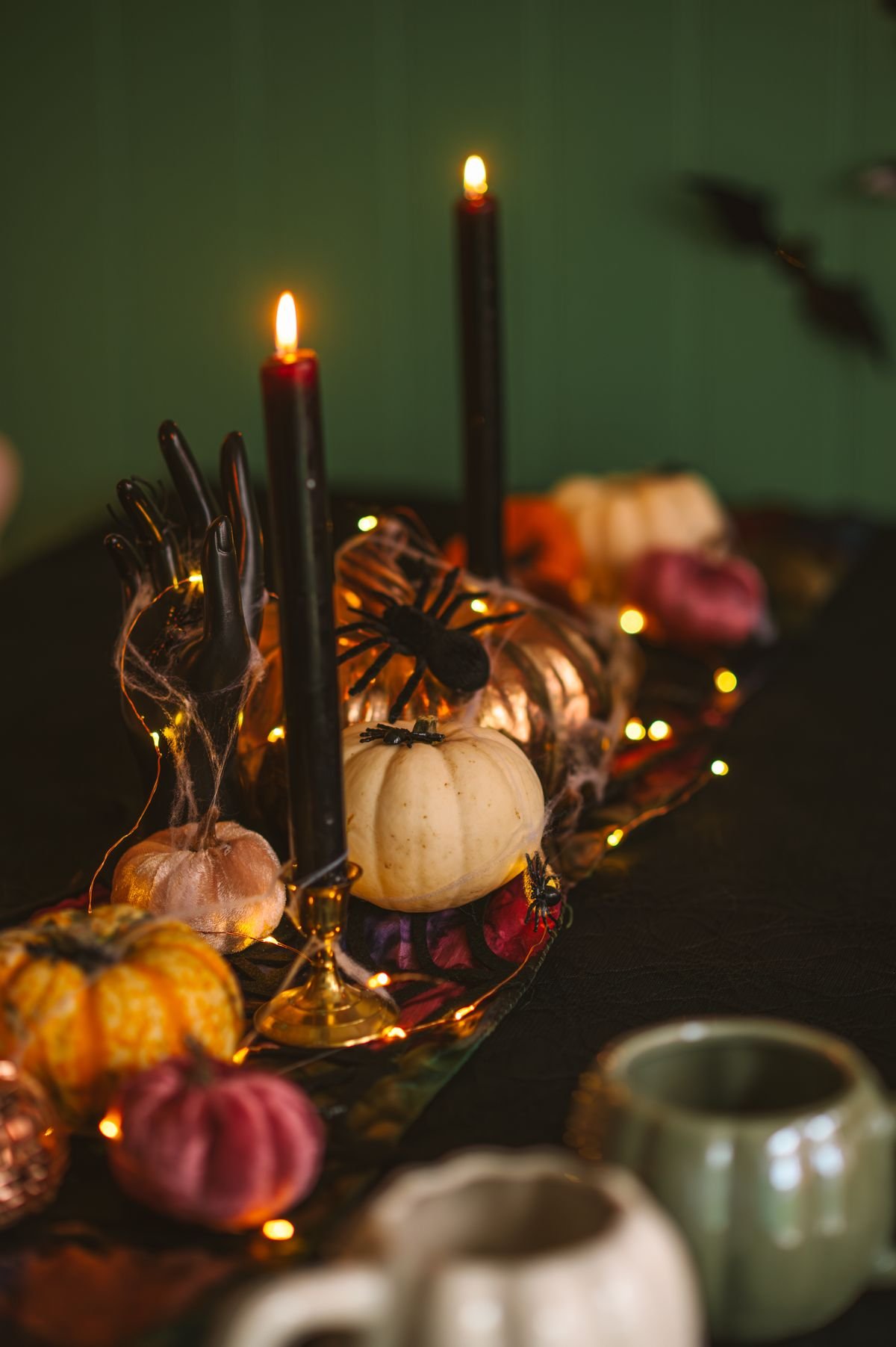 Dining table styled with black candles and pumpkins for a halloween tablescape