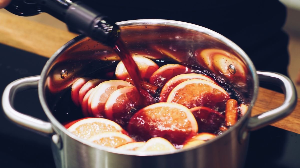 Simmer pot with cinnamon and orange slices on a stove for autumn scent