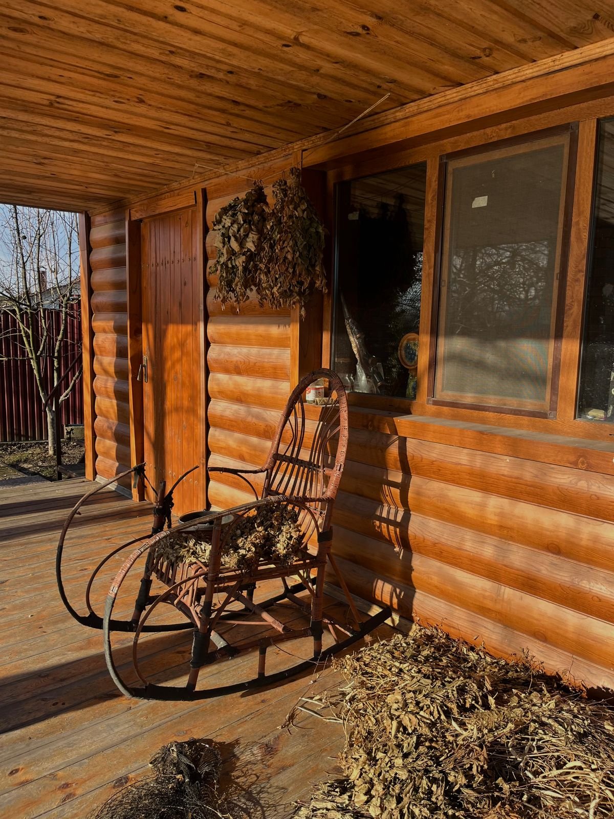 Porch rocking chair with plaid throw and pumpkin