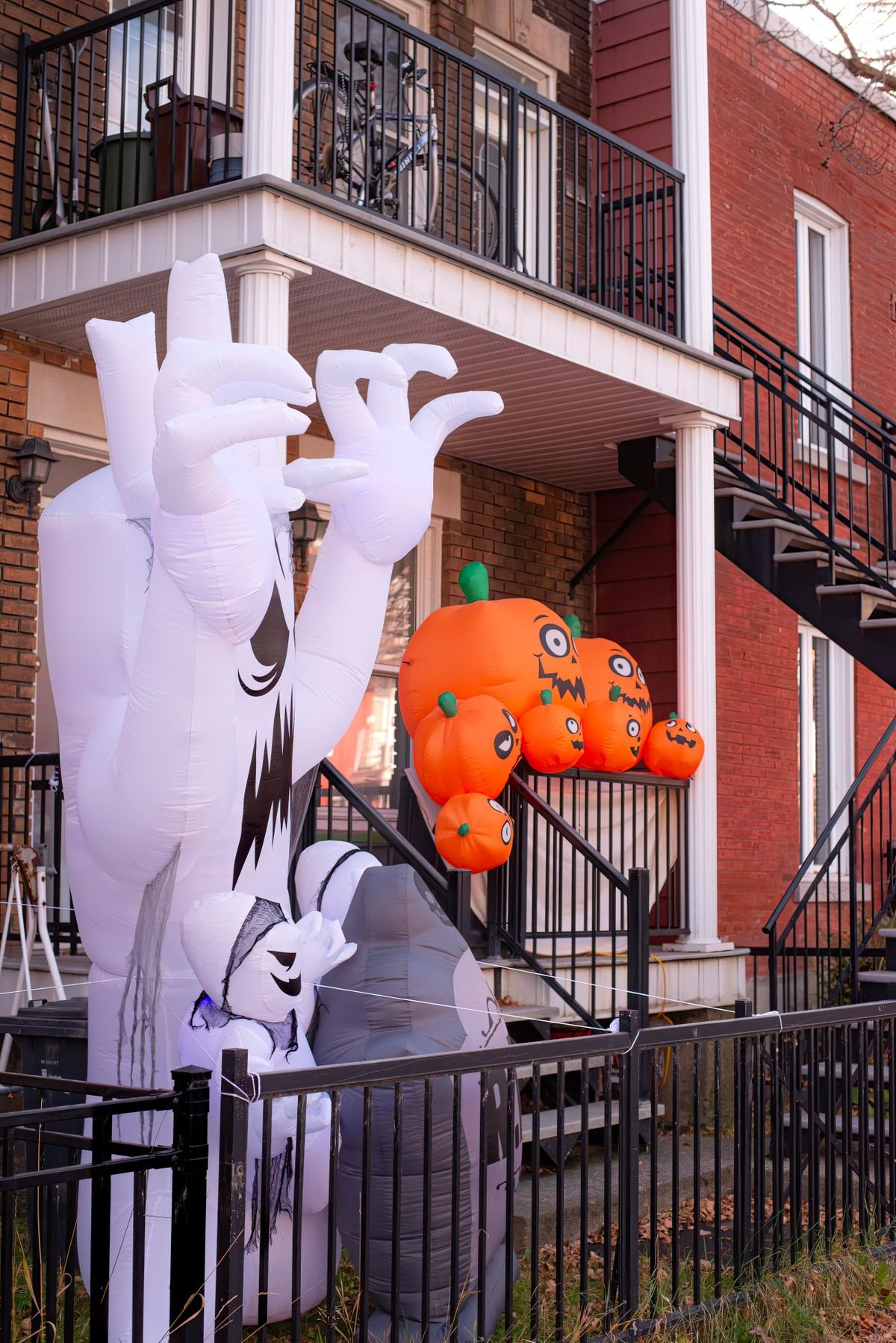 Inflatable ghost and pumpkins on an urban porch for Halloween