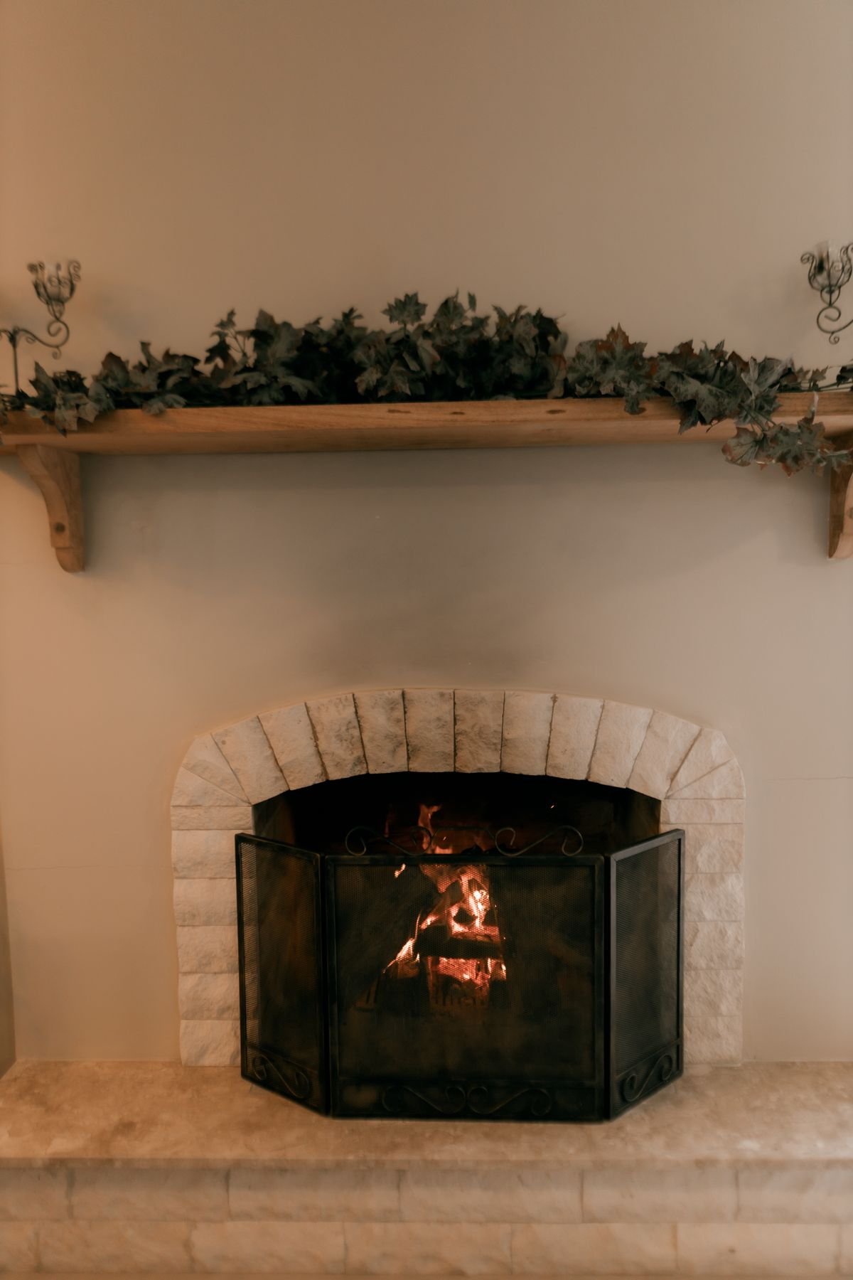 Autumn leaf garland with small paper ghosts hanging over a mantel