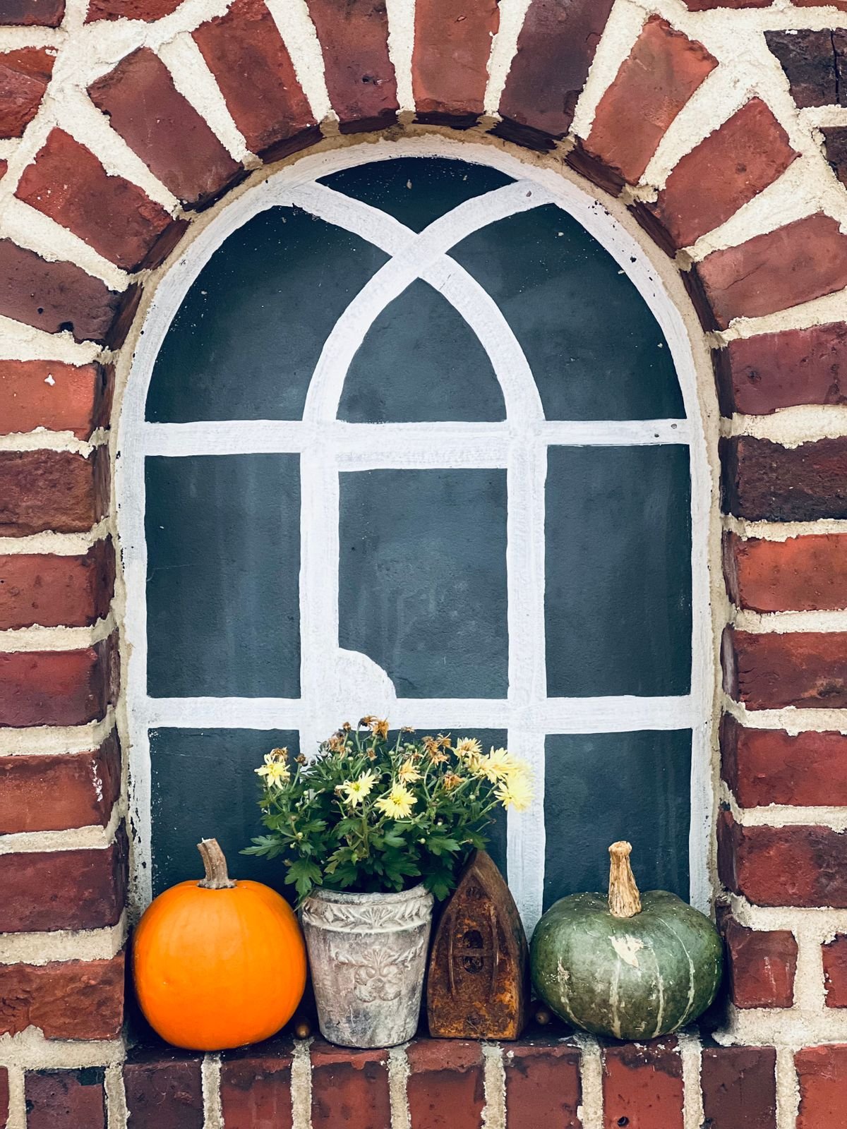 Window box with trailing ivy mini pumpkins and fairy lights for autumn