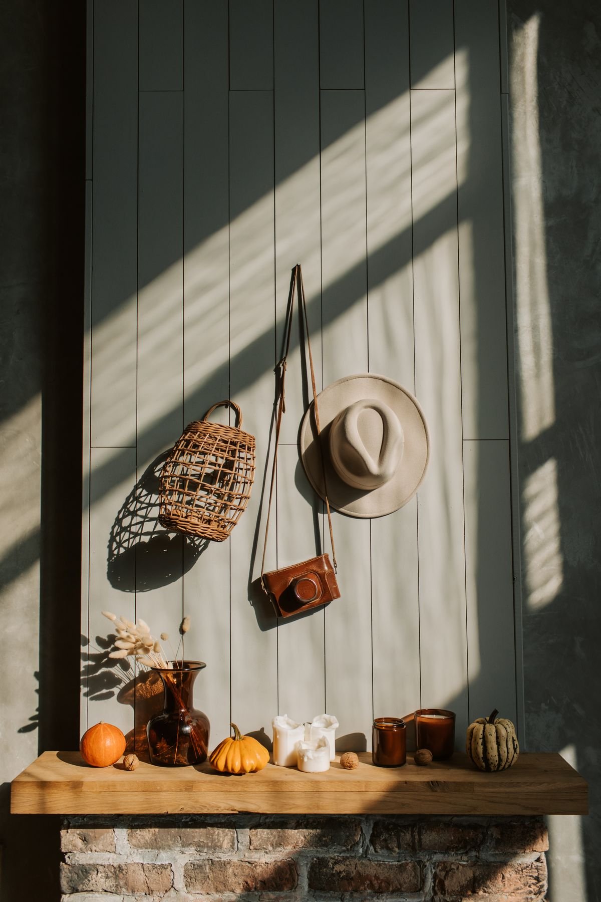 Fireplace mantel with stacked pumpkins wheat bundles and black lantern autumn