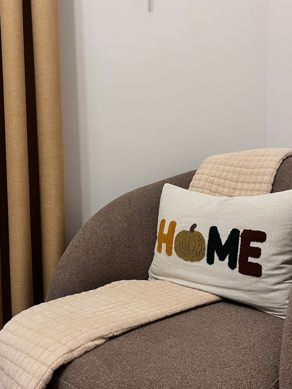 Cozy living room with autumn toned rug rust throw blankets and pumpkins