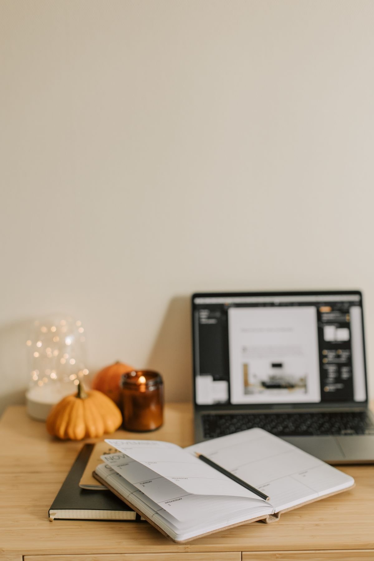Home office desk with pumpkin paperweight and dried eucalyptus autumn