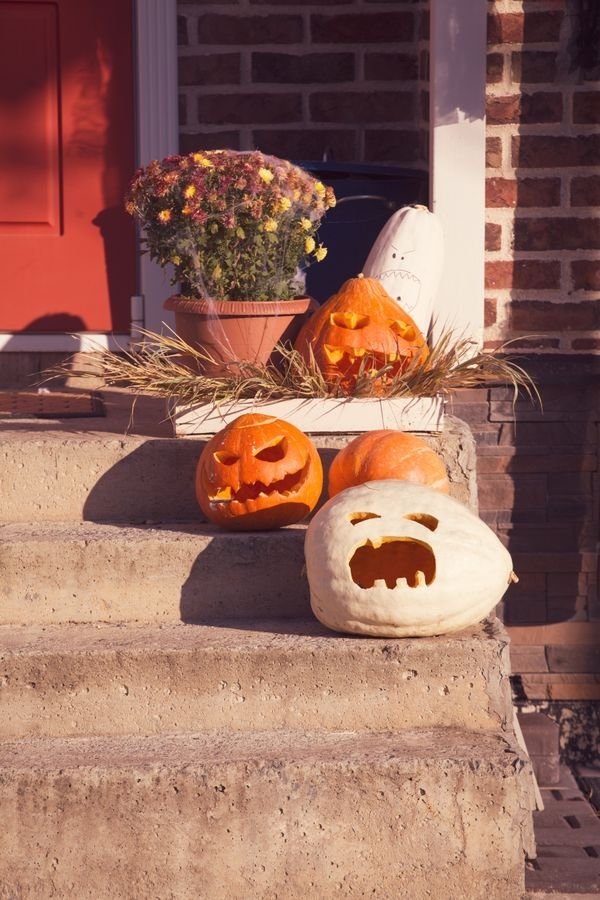 Life-size skeleton posed on a porch chair, spooky front yard ideas