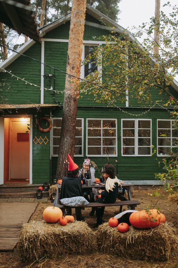 Wooden coffin prop leaning by a front door with lanterns, spooky front yard ideas
