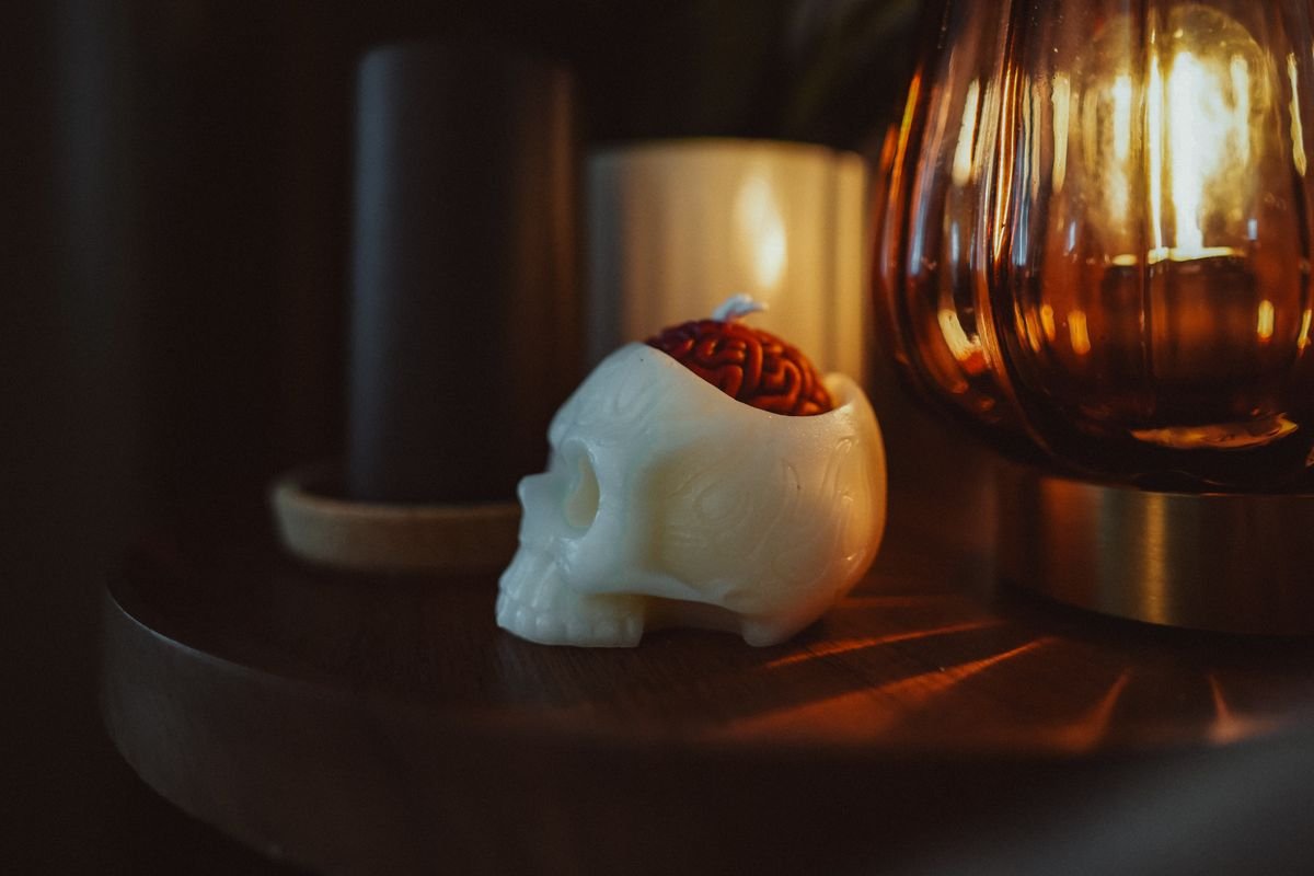 Skull candle glowing warmly on a living room side table for halloween