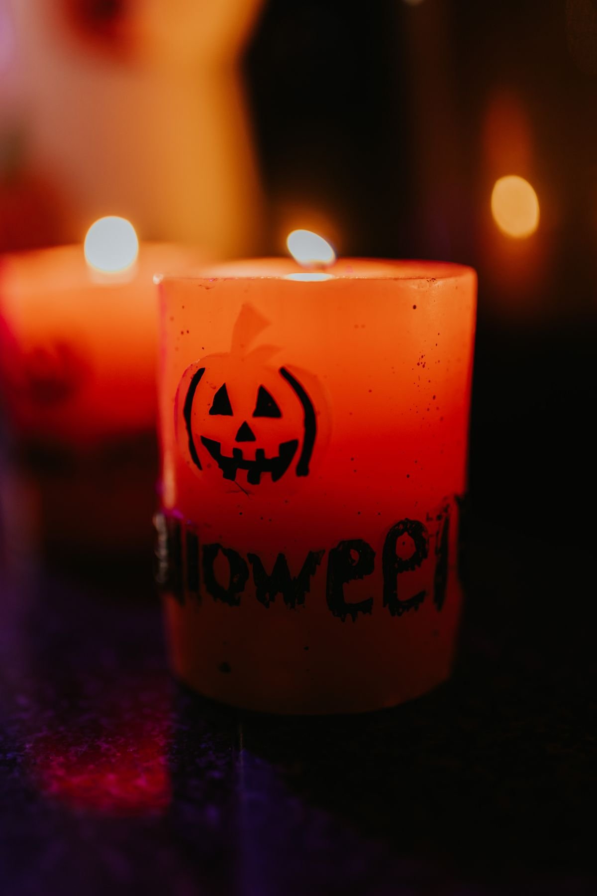 Jack-o'-lantern candle glowing on a drinks table in a halloween living room