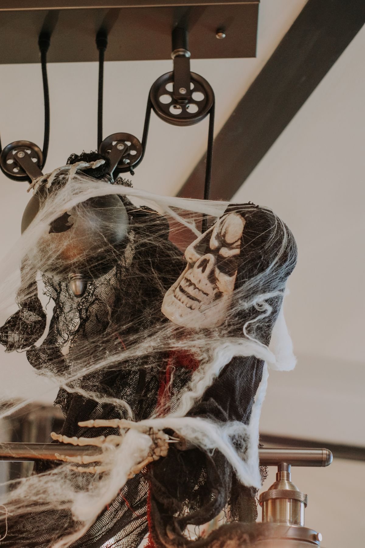 Skeleton decoration with cobwebs tucked into a living room alcove for halloween