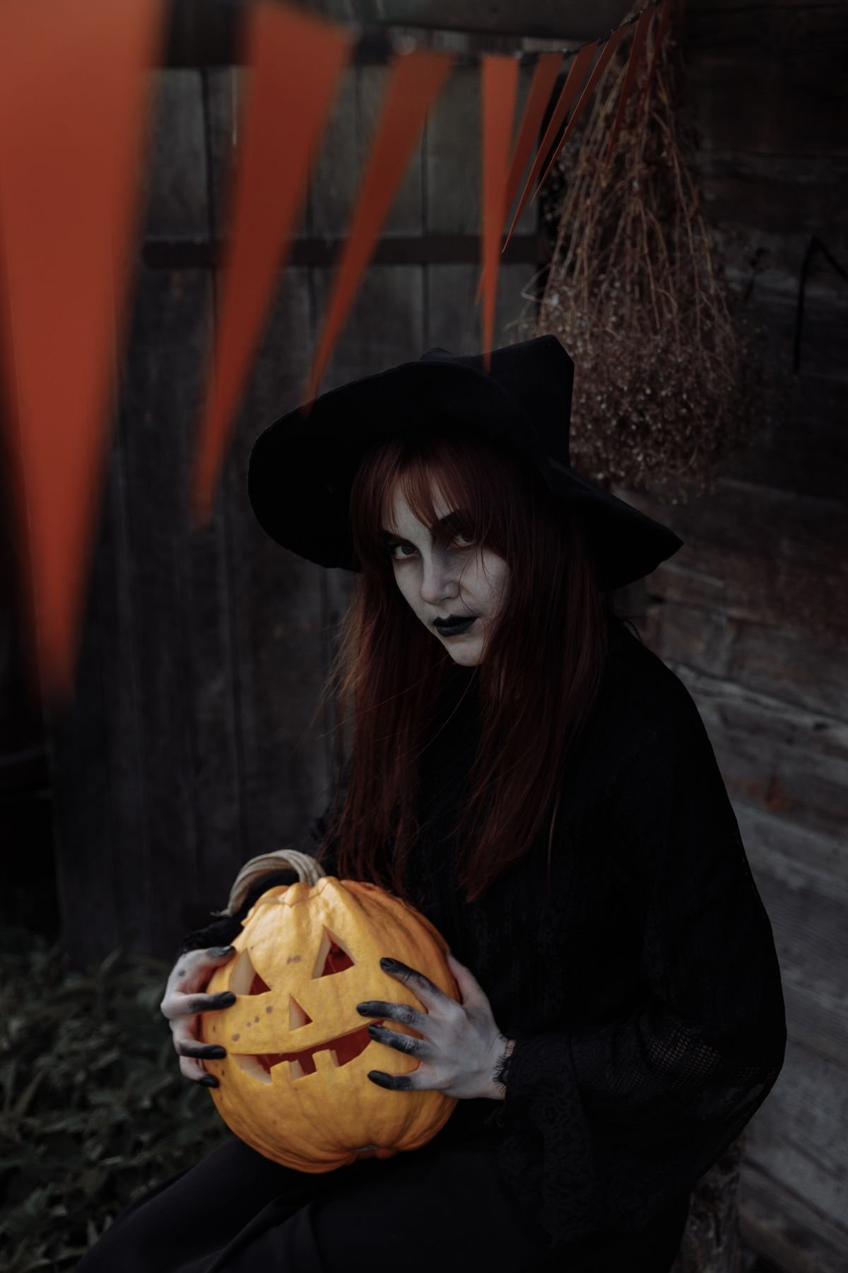 Witch holding a carved jack o lantern for atmospheric outdoor halloween decor