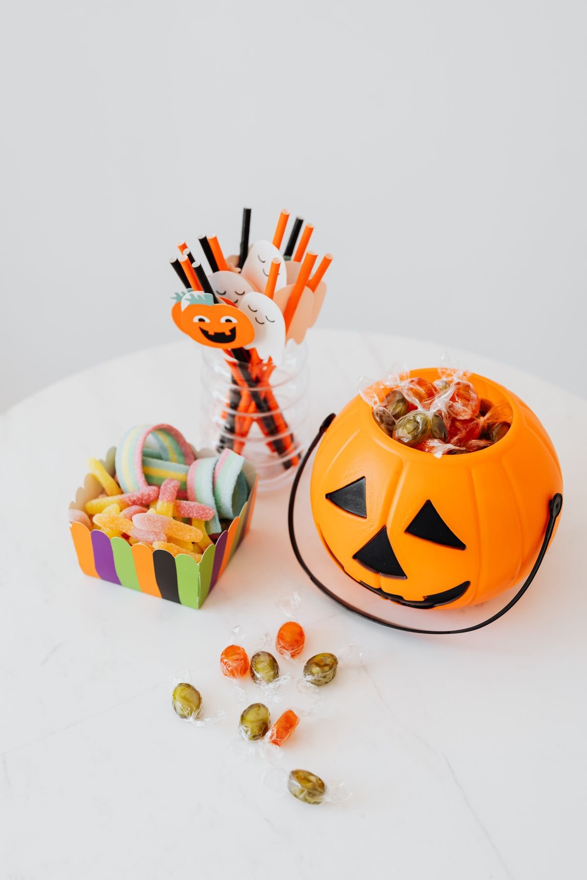 Jack o lantern sweet bucket with halloween treats and straws