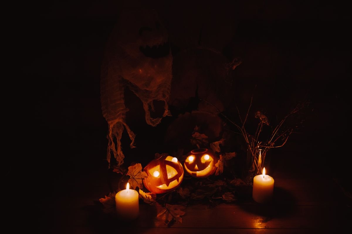 Lit jack o lanterns and candles glowing in the dark, halloween night