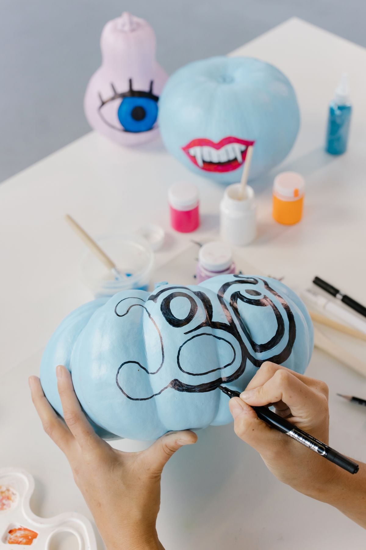 Mini pumpkins hand-painted with white ghost faces