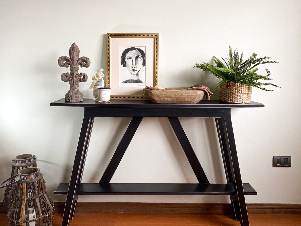 Entryway console with white pumpkins and a beige welcome mat
