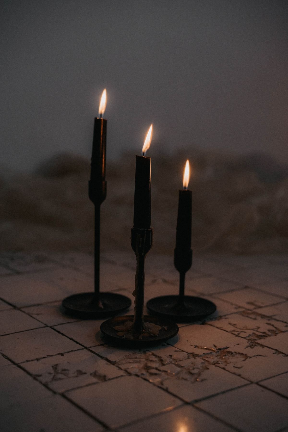 Black pillar candles clustered on a mantel