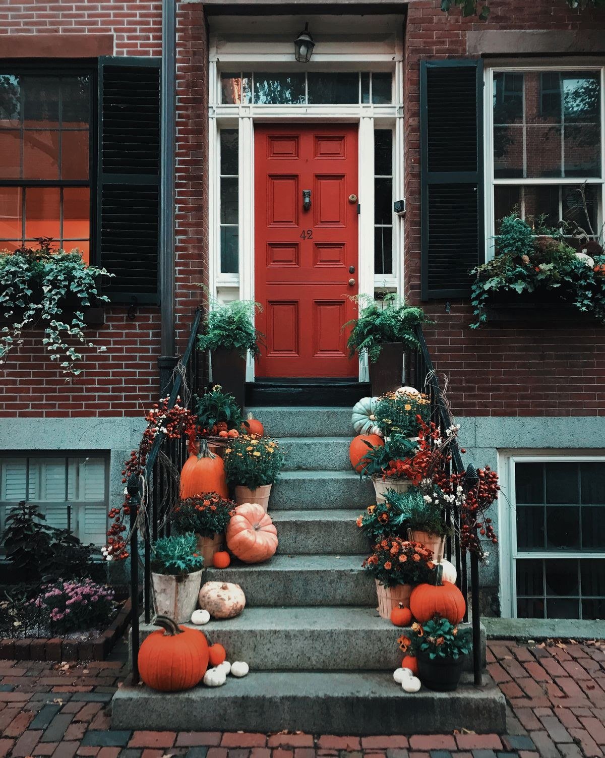 Pumpkins lined on stairs in front of a door for a witch themed entrance