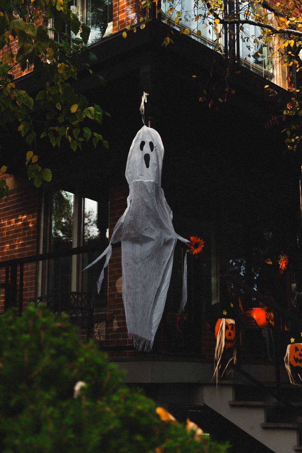 Friendly ghost and pumpkins decorating a house for Halloween